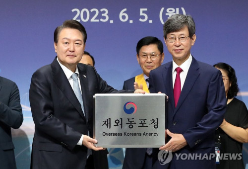 윤석열 대통령이 5일 인천 연수구 부영송도타워에서 열린 재외동포청 출범식에서 이기철 재외동포청장에게 현판을 전달하고 있다.  [대통령실통신사진기자단-연합뉴스] 